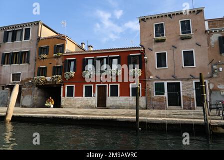 Venedig Straße am Wasser mit Gebäude in verschiedenen Farben. Stockfoto