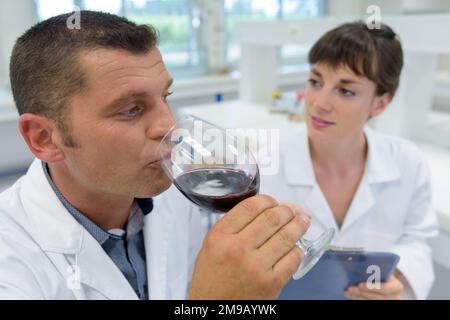 Weinspezialist, der Rotwein im Labor verkostet Stockfoto