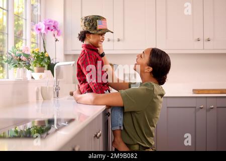 Liebende Amerikanische Armee Mutter In Uniform Zuhause Auf Urlaub Mit Sohn Trägt Ihre Mütze In Der Familienküche Stockfoto