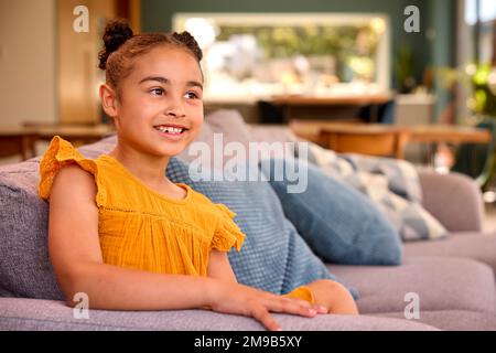 Porträt Eines Lächelnden Mädchens, Das Sich Zu Hause Auf Dem Sofa Entspannen Kann Stockfoto