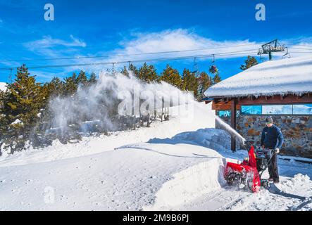 El Tarter, Andorra, Januar 2020 Männer, die handgedrückten Schneepflug mit Rad betreiben und durch Schneeverwehungen schneiden, Schneepulver schießen, Pyrenäen Stockfoto