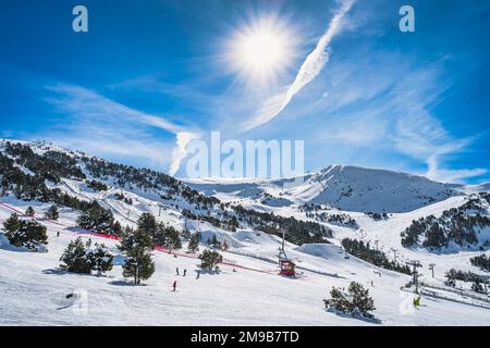 Skifahrer und Snowboarder auf Skipisten und im Schneepark in El Tarter. Schneebedeckte Berge und Wälder. Winterurlaub in Andorra, Pyrenäen Stockfoto