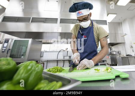 Senior Airman Keshawn Johnson, 374. Force Support Squadron Samurai Café Dining Facility Food Service Jouryman hackt Paprika in Vorbereitung auf das Mittagessen am Yokota Air Base, Japan, 15. Mai 2022. Das DFAC-Team des Yokota Samurai Café besteht aus US-amerikanischen Servicemitarbeitern und japanischen Mitarbeitern, die zusammenarbeiten, um durchschnittlich mehr als 500 Mahlzeiten pro Tag für die Basisbevölkerung zu servieren. Yokotas Restaurant wurde zum zweiten Mal in Folge 2022 mit dem Air Force John L. Hennessy Food Service Excellence Award für die Region 2 ausgezeichnet. Der DFAC von Yokota wurde aufgrund seiner herausragenden Managementwirkung ausgewählt Stockfoto