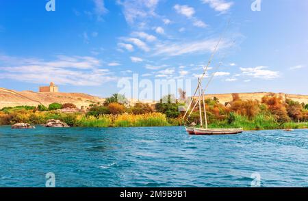 Der Nilblick mit den alten Segelbooten in der Assuan-Wüste, Ägypten Stockfoto