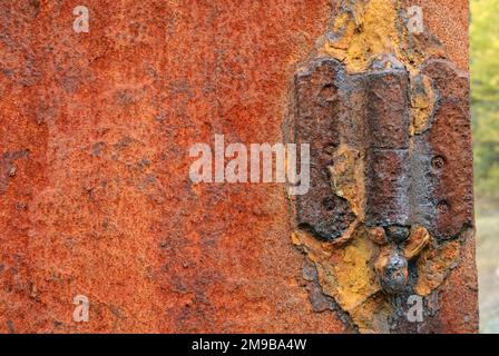 Verrostetes Türscharnier an einer rostigen Metalltür Stockfoto