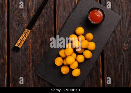 Fischbällchen im Teig mit Essstäbchen - asiatische Küche von oben Stockfoto