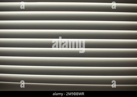 Jalousien am Fenster. Undichte Jalousien. Fenster am Nachmittag. Schutz vor Licht. Stockfoto