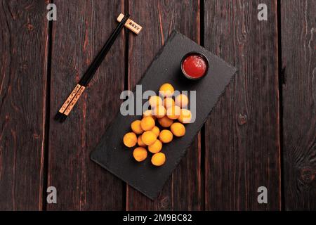 Fischbällchen im Teig mit Essstäbchen - asiatische Küche von oben Stockfoto