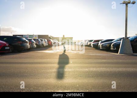 Unscharfes Bild einer Person, die über einen Parkplatz geht Stockfoto