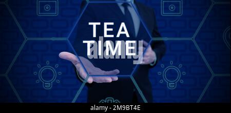 Inspiration mit dem Schild „Tea Time“. Geschäftsleute zeigen die Zeit am Nachmittag, wenn manche Leute eine kleine Mahlzeit essen Stockfoto
