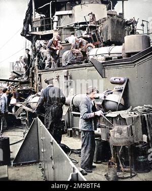 Hafenarbeiter, darunter ein Nieterjunge, der mit einer tragbaren Schmiede arbeitet und die HMS „Coventry“ im Zweiten Weltkrieg 1940 umrüstete. HMS 'Coventry' war ein Royal Navy-Flugabwehr-Kreuzer von 4290 Tonnen. Stockfoto