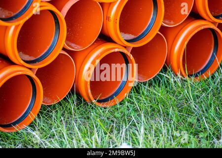 Großer Stapel orangefarbener PVC-Kunststoffrohre Stockfoto