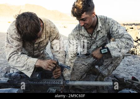 USA Marine Corps CPL. Tadhg P. Kyne und Lance CPL. Reed Mederos, Scout Snipers with Weapons Company, 3. Bataillon, 4. Marine Regiment, anbringen eines integrierten Mini-Modul zur zeigenden Beleuchtung AN/PEQ 16 an ein M110 Semi Automatic Sniper System (M110 SASS) Als Vorbereitung auf den nicht lebendigen Teil des Bodenaufklärungskurses im Marine Corps Air Ground Combat Center, Twentynine Palms, Kalifornien, 16. Mai 2022. Während des Kurses wurden die Marines beauftragt, die Positionen und Bewegungen der Rollenspieler live zu beobachten und zu patrouillieren, ohne unentdeckt zu bleiben. Stockfoto