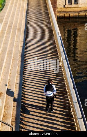 Ein junger Junge, der fröhlich auf einem sonnigen Steinweg spaziert; Fairmount Water Works; Philadelphia; Pennsylvania; USA Stockfoto