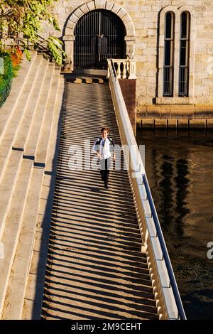Ein junger Junge, der fröhlich auf einem sonnigen Steinweg spaziert; Fairmount Water Works; Philadelphia; Pennsylvania; USA Stockfoto
