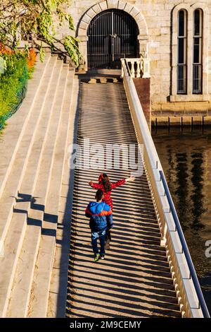 Junge und Mädchen springen fröhlich über den sonnigen Steinweg; Fairmount Water Works; Philadelphia; Pennsylvania; USA Stockfoto
