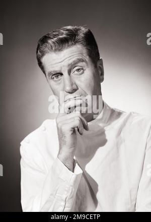 1950S BESORGTER ARZT LÄCHELT ERNSTHAFT GESICHTSAUSDRUCK VON DER HAND ZUM KINN TRÄGT WEISSE LEINEN SEITENTASTE HEMD SCHAUT IN DIE KAMERA - M1645 DEB001 HARS NOSTALGIE ALTE MODE 1 GESICHTSSTIL ANGST KOMMUNIKATION KARRIERE SORGEN JOB STUDIO SHOT MOODY KRANKHEIT KOPIE MENSCHEN IM WELTRAUM PFLEGEN MÄNNER KINN BERUF AUSDRÜCKE BEUNRUHIGT B&W MITTLEREN ALTERS BEFASSTE SICH MIT TRAURIGKEIT MANN MITTLEREN ALTERS LEINEN AUGENKONTAKT GESUNDHEITSKOMPETENZ BERUF FÄHIGKEITEN PRÄVENTION KOPF UND SCHULTERN ANBIETER ANBIETER PRAKTIKER HEILEN DIAGNOSE KARRIERE ÄRZTE SCHLECHTE NACHRICHTEN GESUNDHEIT BEEINTRÄCHTIGUNG STIMMUNGSLAGE BERUFE BEHANDLUNG HEILERTRÜBUNGEN Stockfoto