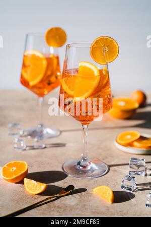 Nahaufnahme von zwei aperol Spritz Drinks auf sonnigem beigefarbenem Hintergrund. Stockfoto