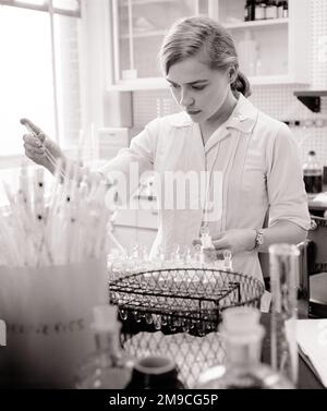 1960S BLONDE FRAU KRANKENHAUS LABORTECHNIKERIN ARBEITET IN EINEM KRANKENHAUS BLUTBANK - M7771 HAR001 HARS BLUT BERUF VERTRAUEN B&W ZIELE GESUNDHEIT QUALIFIKATION BERUF FÄHIGKEITEN PRÄVENTION HEILUNG WISSENSCHAFTLICHE DIAGNOSE KARRIERE ARBEIT GESUNDHEIT BESCHÄFTIGUNG BESCHÄFTIGUNG BESCHÄFTIGUNG BEHANDLUNG KRANKENHÄUSER INFRASTRUKTUR MITARBEITER DER EINRICHTUNG EINRICHTUNGEN FOKUSSIERT INTENSIVE JUNGE ERWACHSENE FRAU SCHWARZ-WEISS WEISSE ETHNISCHE ZUGEHÖRIGKEIT HAR001 INTENT LABORS LABING LABS ALTMODISCH Stockfoto
