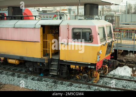 Reparatur von Schienenfahrzeugen. Gelber Zug zum Verlegen von Eisenbahnschienen. Stockfoto