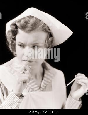 1930S BESORGTE KRANKENSCHWESTER, DIE AUF FIEBER PRÜFT, HÄLT EINEN ALTMODISCHEN MAXIMALEN QUECKSILBER-IN-GLAS-SHAKE, UM MEDIZINISCHES THERMOMETER ZURÜCKZUSETZEN - N1007 HAR001 HARS SHAKE WEIBLICHE THERMOMETER JOBS STUDIO SHOT COPY SPACE DAMEN PFLEGEN RISIKO BERUF EXPRESSIONEN B&W SORGTE FÜR TRAURIGKEIT GESUNDHEITSWESEN QUALIFIKATION BERUF TEMPERATUR FÄHIGKEITEN KOPF UND SCHULTERN ANBIETER FIEBER ANBIETER ENTDECKER PRAKTIZIERENDE HEILUNG KARRIERE GESUNDHEIT UND GESCHLOSSENE BERUFE HEILER PRAKTIZIERENDE MAXIMALE MITTLERE ERWACHSENE FRAUEN PROFIS SCHWARZ-WEISS WEISSE ETHNISCHE ZUGEHÖRIGKEIT HAR001 ALTMODISCH Stockfoto