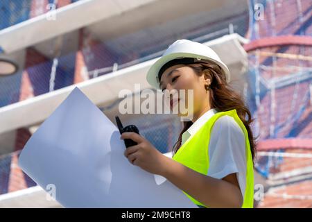Weibliche Architektin, die sich Baupläne ansieht Stockfoto
