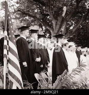 1960S HIGH SCHOOL-JUNGEN IN SCHWARZEN BADEMÄNTELN MÄDCHEN IN WEISSER OUTDOOR-FLAGGE - S17580 HAR001 HARS-FRAUEN-DIPLOM UNITED STATES COPY SPACE FRIENDSHIP PERSONEN MIT HALBER LÄNGE INSPIRATION UNITED STATES OF AMERICA MÄNNER TEENAGER TEENAGE BOY, DER B&W NORTH STUDIERT AMERIKA FREIHEITSZIELE NORDAMERIKANISCHE SCHULEN ERFOLG TRÄUME GLÜCK UMHÜLLT AUFREGUNG WISSEN FÜHRUNGSSTOLZ GELEGENHEIT HIGH SCHOOL HIGH SCHOOL KONZEPT STERNE UND STREIFEN TEENAGER MORTARBOARD OLD GLORY KOOPERATION WACHSTUM ROT WEISS UND BLAU ZUSAMMENGEHÖRIGKEIT SCHWARZ UND WEISS KAPPE UND KLEID KAUKASISCHE ETHNISCHE ZUGEHÖRIGKEIT HAR001 Stockfoto