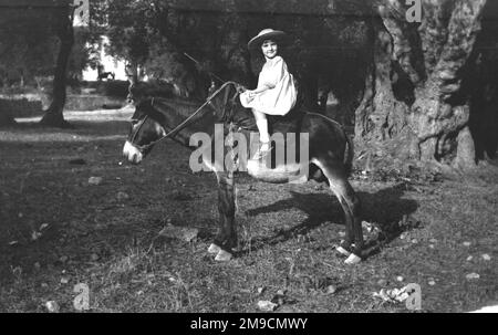 Ein kleines Mädchen, das auf einem Esel reitet Stockfoto