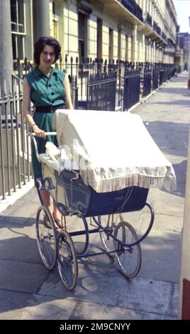 Eine junge Frau mit einem Kinderwagen in Draycott Place, im Londoner Stadtteil Kensington und Chelsea. Stockfoto