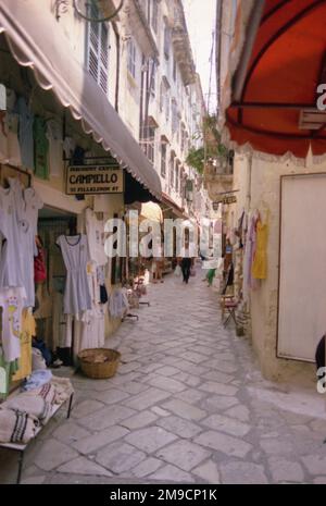Eine malerische Seitenstraße in Korfu, Griechenland, mit Geschäften auf beiden Seiten. Stockfoto