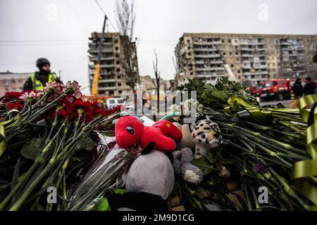 Dnipro, Ukraine. 17. Januar 2023. Vor dem zerstörten Wohngebäude sind Blumen zu sehen, die nach einem Raketenangriff vor 4 Tagen in der ukrainischen Stadt Dnipro am 17. Januar 2023 entstanden sind. Mehr als 40 Opfer, darunter Kinder, wurden getötet, als am Samstag eine russische Rakete auf ein Wohngebäude traf. Foto: Dnipropetrovsk State Administration/UPI Credit: UPI/Alamy Live News Stockfoto