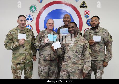 Fünf der 135 Soldaten des 135. Expeditionary Sustainment Command (ESC) haben ihre Geburtstagskarten für den letzten bekannten Tuskegee Airman, Sergeant Victor Butler. Butler war Mechaniker der Tuskegee Airmen, und er war einer der vielen schwarzen Militärpiloten und Flugzeuge, die während der Kämpfe im Zweiten Weltkrieg Geschichte schrieben Zusätzlich zu diesen Opfern hat die Einheit Barrieren durchbrochen und maßgeblich zur Aufhebung der Segregation des US-Militärs beigetragen. Von links nach rechts: Sgt. 1. Klasse Brian Lynd, Oberstleutnant Joel Traweek, Sgt. 1. Klasse Willie Vandiver, Kapitän Jeremy Barrett und Sgt. 1. CL Stockfoto