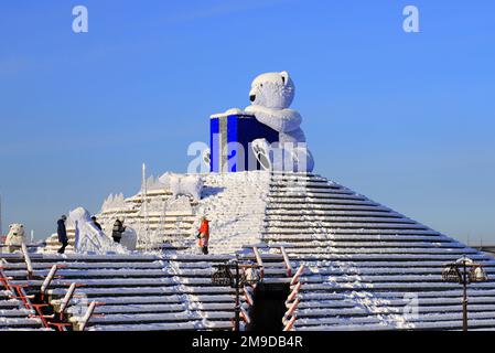 Großer Eisbär steht im Winter auf der Straße der Stadt, festliches Spielzeug. Die Leute gehen unter Weihnachtsdekorationen und Installationen. Dnipro, Ukraine 2022-01-02 Stockfoto