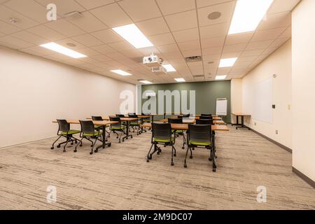 Innenausstattung eines Schulungs-, Besprechungs- und Konferenzraums mit Schreibtischen, Stühlen und Whiteboard. Niemand im Bild enthalten. Stockfoto