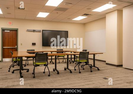 Innenausstattung eines Schulungs-, Besprechungs- und Konferenzraums mit Schreibtischen, Stühlen und Whiteboard. Niemand im Bild enthalten. Stockfoto