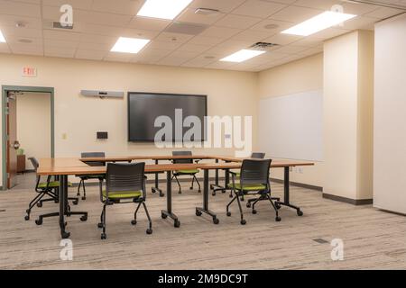 Innenausstattung eines Schulungs-, Besprechungs- und Konferenzraums mit Schreibtischen, Stühlen und Whiteboard. Niemand im Bild enthalten. Stockfoto