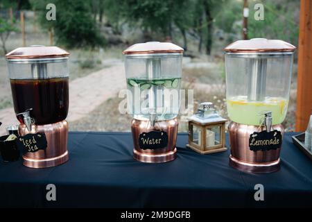 Drei Gläser mit erfrischenden Getränken - Limonade, Wasser und Eistee auf marineblauer Tischdecke Stockfoto