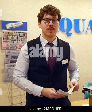 Bad Doberan, Deutschland. 17. Januar 2023. Michel Polak Carlota aus São Paulo (Brasilien), ein potenzieller Geschäftsmann für Tourismus und Freizeit, an der Rezeption. Der 32-Jährige arbeitet derzeit im Rahmen des Projekts „Hand in Hand für internationale Talente“ als Hotelrezeptionist im vier-Sterne-Hotel Aquamarin. Auf einer Presseveranstaltung am 19.01.2023 in Heiligendamm werden das Projekt von der Bundesagentur für Arbeit, der Arbeitsagentur Rostock und der Industrie- und Handelskammer IHK von Rostock vorgestellt. Kredit: Bernd Wüstneck/dpa/Alamy Live News Stockfoto