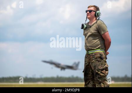 USA Air Force Airman 1. Class Leo Johansson, 142. Aircraft Maintenance Squadron Crew Chief, Portland Air National Guard Base, Oregon, wartet auf den Start eines F-15C Eagle, während eine F-15 der 131. Kampfgeschwader, Barnes ANG Base, Massachusetts, Startet während des Waffensystem-Evaluierungsprogramms East 22,08 auf dem Luftwaffenstützpunkt Tyndall, Florida, 17. Mai 2022. Bei der WSEP handelt es sich um eine formelle, zweiwöchige Evaluierungsübung, bei der die Fähigkeiten eines Geschwaders zur Durchführung von Feuerwaffensystemen während Luft-Luft-Ausbildungsmissionen getestet werden sollen. Stockfoto