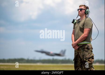 USA Air Force Airman 1. Class Leo Johansson, 142. Aircraft Maintenance Squadron Crew Chief, Portland Air National Guard Base, Oregon, wartet auf den Start eines F-15C Eagle, während eine F-15 der 131. Kampfgeschwader, Barnes ANG Base, Massachusetts, Startet während des Waffensystem-Evaluierungsprogramms East 22,08 auf dem Luftwaffenstützpunkt Tyndall, Florida, 17. Mai 2022. Bei der WSEP handelt es sich um eine formelle, zweiwöchige Evaluierungsübung, bei der die Fähigkeiten eines Geschwaders zur Durchführung von Feuerwaffensystemen während Luft-Luft-Ausbildungsmissionen getestet werden sollen. Stockfoto