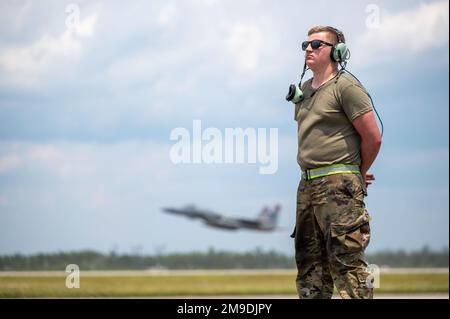 USA Air Force Airman 1. Class Leo Johansson, 142. Aircraft Maintenance Squadron Crew Chief, Portland Air National Guard Base, Oregon, wartet auf den Start eines F-15C Eagle, während eine F-15 der 131. Kampfgeschwader, Barnes ANG Base, Massachusetts, Startet während des Waffensystem-Evaluierungsprogramms East 22,08 auf dem Luftwaffenstützpunkt Tyndall, Florida, 17. Mai 2022. Bei der WSEP handelt es sich um eine formelle, zweiwöchige Evaluierungsübung, bei der die Fähigkeiten eines Geschwaders zur Durchführung von Feuerwaffensystemen während Luft-Luft-Ausbildungsmissionen getestet werden sollen. Stockfoto