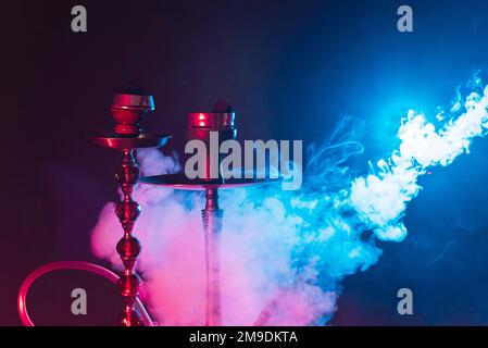 Moderner Hookah, Shisha rauchiger schwarzer Hintergrund mit farbigem Licht und Rauch. Schließen Stockfoto