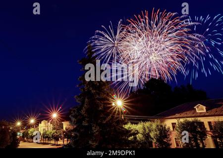 Bunte Feuerwerkskörper über der Stadt in der Feiernacht Stockfoto