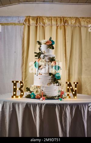 Weiße und rote Rosen mit Schnittkuchen auf Hochzeitsempfang Stockfoto