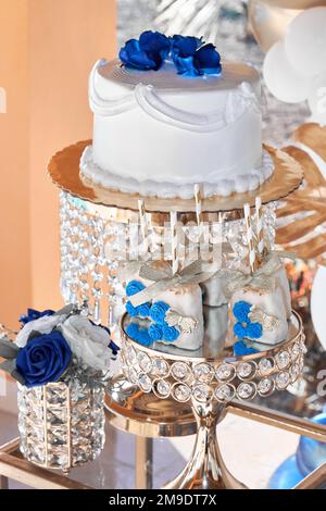 Weiße und rote Rosen mit Schnittkuchen auf Hochzeitsempfang Stockfoto