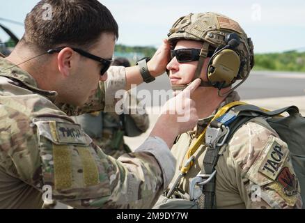 (Links) Tech. Sergeant Brian C. Melendrez, Sprungmeister beim 14. Air Support Operations Squadron, überprüft, ob die Ausrüstung und der Fallschirm auf einem Airman des 148. Air Support Operations Squadron, Pennsylvania Air National Guard, während des Flugtrainings am 18. Mai 2022 in Fort Indiantown Gap, Pa, sicher sind Jedes Mitglied des Dienstes wurde mehrmals überprüft, bevor sie von der Rampe sprangen, die PA Army National Guard CH-47 Chinook Stockfoto