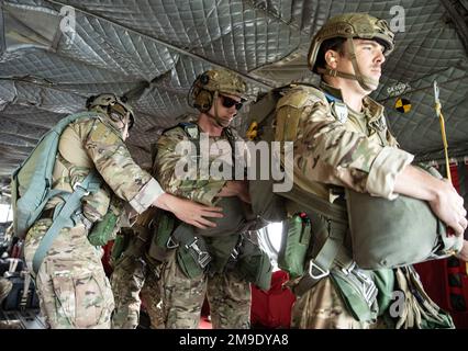 (Links) Tech. Sergeant Brian C. Melendrez, Sprungmeister der 14. Air Support Operations Squadron, führt eine letzte Prüfung der nächsten Kreide durch, um sich auf ihren Sprung vorzubereiten, während des Flugtrainings am 18. Mai 2022 in Fort Indiantown Gap, Pa Die Ausbildung war ein gemeinsames Unterfangen zwischen den 14. ASOS, 148. ASOS und den Piloten und der Crew der CH-47 von der Pennsylvania Army National Guard Stockfoto