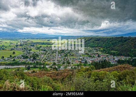 Reefton vom Aussichtspunkt südlich von Reefton aus gesehen, mit dem Inangahua River im Vordergrund und dem Victoria Forest Park auf der rechten Seite. Stockfoto