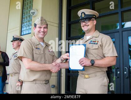 POLARIS POINT, Guam (18. Mai 2022) Senior Chief Hospital Corpsman Cody Werven, rechts, schüttelt sich die Hand mit Captain Carl Trask, Commander, U-Boot-Geschwader 15, während einer Beförderungszeremonie am 18. Mai. Kommandant, U-Boot-Geschwader 15 ist verantwortlich für Ausbildung, Material und Personaleinsatzunterstützung für mehrere schnell angreifende U-Boote der Los Angeles-Klasse und befindet sich am Polaris Point, Marinebasis Guam. Stockfoto