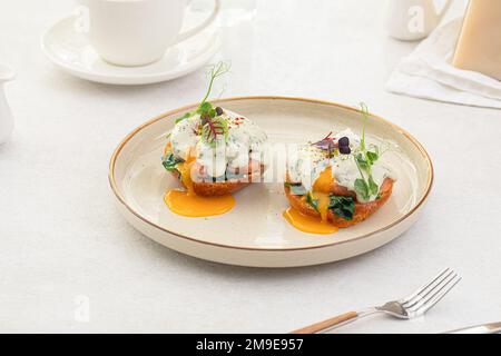 Eine Portion benedikt-Ei mit Dor-Blue-Sauce Stockfoto